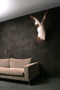 Dunkle edle Kalkputz-Wand hinter modernem Sofa im minimalistischen Wohnraum